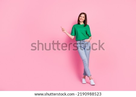 Full body photo of stunning young girl hold hand pocket point empty space dressed trendy green clothes isolated on pink color background