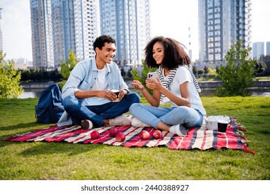 Full body photo of two beautiful people sit blanket drink coffee use smart phone sunshine megapolis outdoors - Powered by Shutterstock