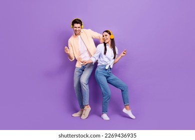 Full body photo of two carefree overjoyed people chilling dance enjoy playlist isolated on violet color background