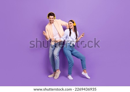 Full body photo of two carefree overjoyed people chilling dance enjoy playlist isolated on violet color background