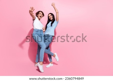 Full body photo of two careless girls sisters have fun shopaholic celebrate black friday discount offer isolated on pink color background