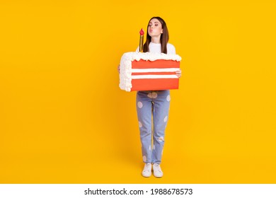 Full Body Photo Of Young Attractive Woman Hold Birthday Cake Blow Candle Isolated Over Yellow Color Background