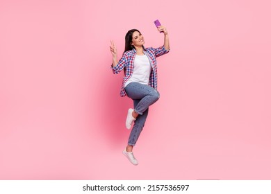 Full Body Photo Of Young Brunette Lady Jump Do Selfie Wear Shirt Jeans Shoes Isolated On Pink Background