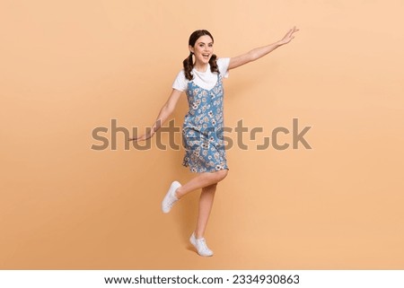 Full body photo of young carefree girl ponytails hair arms wings flying over street summertime mood isolated on beige color background
