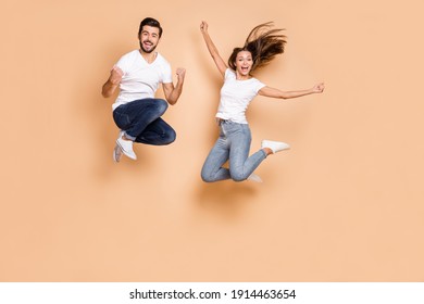 Full Body Photo Of Young Excited Couple Happy Positive Smile Active Jump Up Wear Denim Isolated Over Beige Color Background