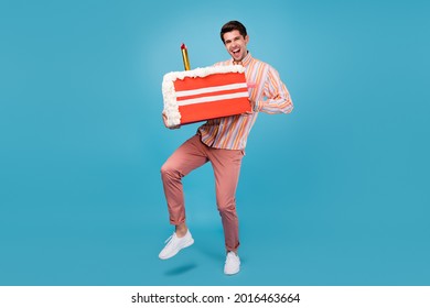Full body photo of young guy happy positive smile hold cake sugar sweet birthday isolated over blue color background