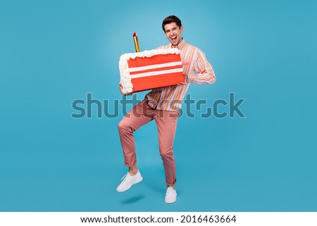 Full body photo of young guy happy positive smile hold cake sugar sweet birthday isolated over blue color background