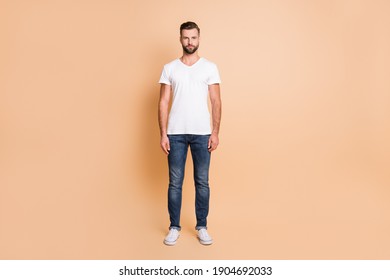 Full body photo of young handsome man confident serious wear casual outfit isolated over beige color background - Powered by Shutterstock