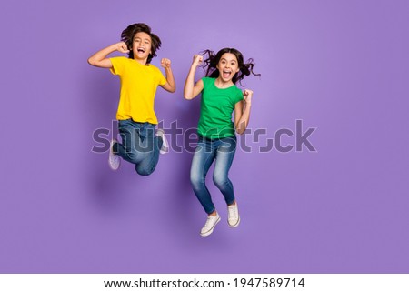 Full body photo of young kids happy smile jump up celebrate win victory success fists hands isolated over purple color background