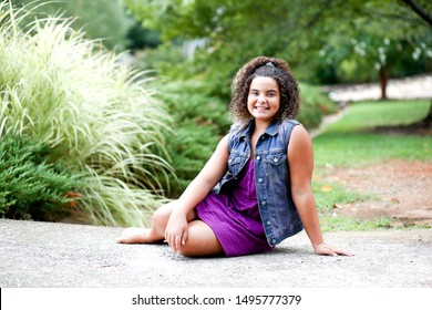 Full Body Picture Of Beautiful Biracial African American Black Tween Girl Lounging Outdoor At Nature Park In The Summer