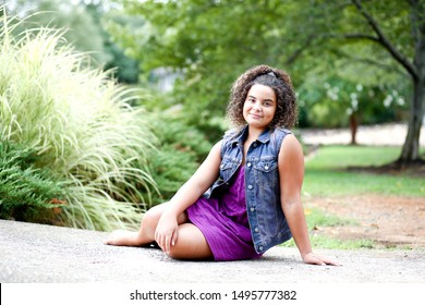 Full Body Picture Of Beautiful Biracial African American Black Tween Girl Lounging Outdoor At Nature Park In The Summer