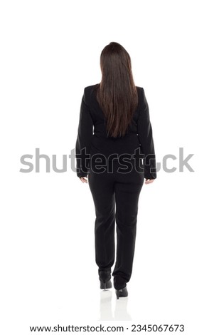 full body picture of businesswoman walking, standing and posing in a back view position on white studio background