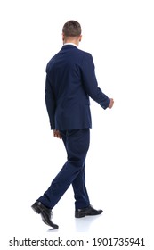 full body picture of elegant fashion model in navy blue suit walking isolated on white background in studio