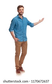 Full Body Picture Of A Young Casual Man Presenting Something On White Background