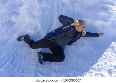 Full Body Portrait Of Asian Fat Man Wearing Eyeglasses In Blue Overcoat With T-shirt Inside And Blue Jeans Lays Down On The Snow Field And Act Like Flying In The Air Like Superman. He Look Funny.