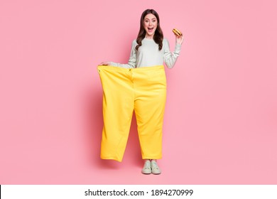 Full Body Portrait Of Astonished Person Big Pants Hand Hold Cheeseburger Open Mouth Isolated On Pink Color Background