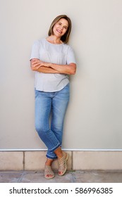 Full Body Portrait Of Attractive Senior Woman Smiling With Arms Crossed