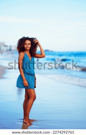 full body portrait beautiful young brazilian woman standing on the shore of the beach in Ipanema, Rio de Janeiro	
