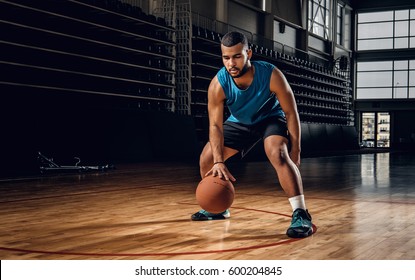 Full body portrait of Black professional basketball player in an action in basketball field. - Powered by Shutterstock