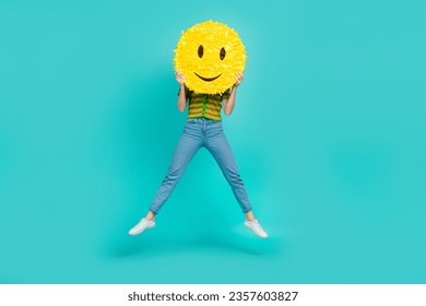 Full body portrait of carefree crazy lady jumping arms hold big smiley emoji isolated on turquoise color background