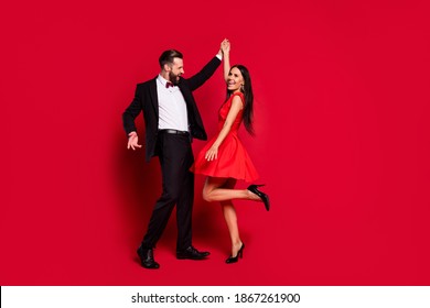 Full body portrait of carefree handsome guy attractive lady have fun enjoy dance isolated on red color background - Powered by Shutterstock