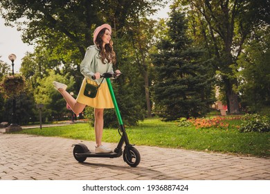 Full Body Portrait Of Charming Positive Girl Driving Scooter Raise Foot Look Far Away Spend Weekend Outdoors