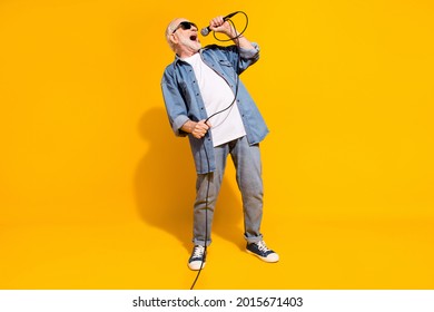 Full Body Portrait Of Excited Positive Man Hand Hold Mic Singing Loud Open Mouth Isolated On Yellow Color Background