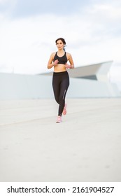 Full Body Portrait Of Fit Young Woman Running Outside In Morning