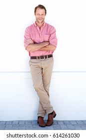 Full Body Portrait Of Handsome Older Man Smiling Against White Wall