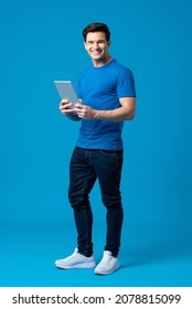 Full Body Portrait Of Happy Caucasian American Man Holding Tablet Computer Isolated On Blue Studio Background