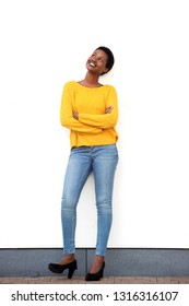 Full Body Portrait Of Happy Young African American Woman Standing Against White Wall And Looking Up