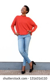 Full Body Portrait Of Happy Young African American Woman Standing Against White Wall