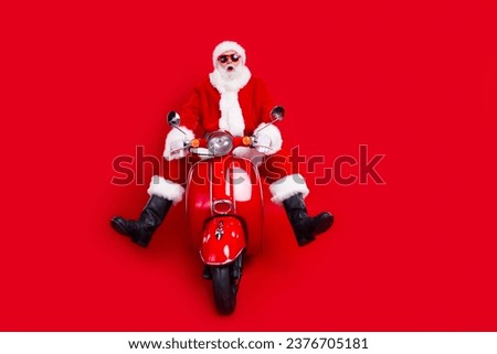 Full body portrait of impressed speechless charismatic santa drive scooter empty space new year advert isolated on red color background