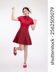 Full body portrait of joyful beauty Asian woman in red Cheongsam Chinese traditional dress celebrating and dancing isolated on white background.