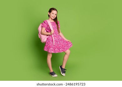 Full body portrait of lovely schoolgirl backpack empty space wear pink dress isolated on green color background - Powered by Shutterstock