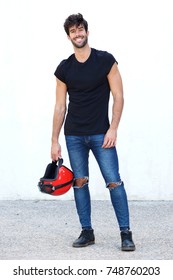 Full Body Portrait Of Motorcyclist With Helmet And Ripped Jeans