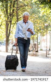 Full Body Portrait Older Man Walking With Mobile Phone And Suitcase On City Street