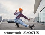 Full body portrait of positive funky woman learning to ride on roller skates