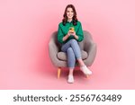 Full body portrait of pretty positive lady sit comfort chair use smart phone chatting isolated on pink color background