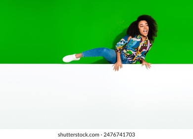 Full body portrait of pretty young woman climb over empty space empty space isolated on green color background - Powered by Shutterstock