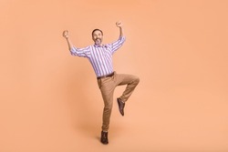 Full Body Portrait Of Satisfied Glad Person Stand One Leg Raise Fists Attainment Luck Empty Space Isolated On Beige Color Background