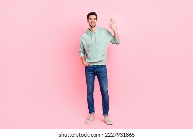 Full body portrait of satisfied young person arm palm waving hello hi isolated on pink color background - Powered by Shutterstock