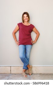 Full Body Portrait Of Senior Woman Smiling Against Wall