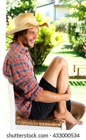 Full Body Portrait Of Smiling Young Man Wearing Cowboy Hat Outside