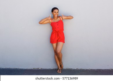 Full Body Portrait Of Smiling Young Woman With Thumbs Up