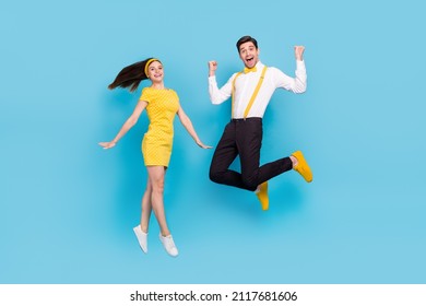 Full Body Portrait Of Two Active Overjoyed People Raise Fists Enjoy Holiday Isolated On Blue Color Background