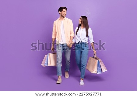 Full body portrait of two idyllic nice people hold hands walk store mall packages isolated on purple color background Foto stock © 