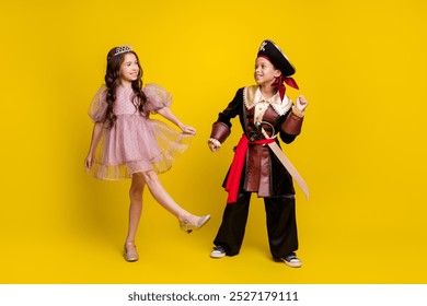 Full body portrait of two small kids enjoy dancing halloween pirate princess costume isolated on yellow color background - Powered by Shutterstock