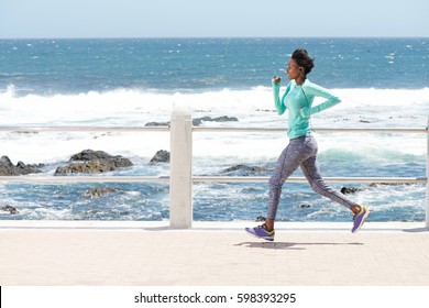 Full Body Portrait Of Young African American Woman Running By The Sea