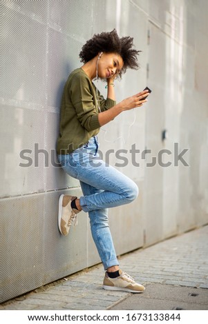 Similar – Serious black woman with afro hair looking at her smart phone outdoors.